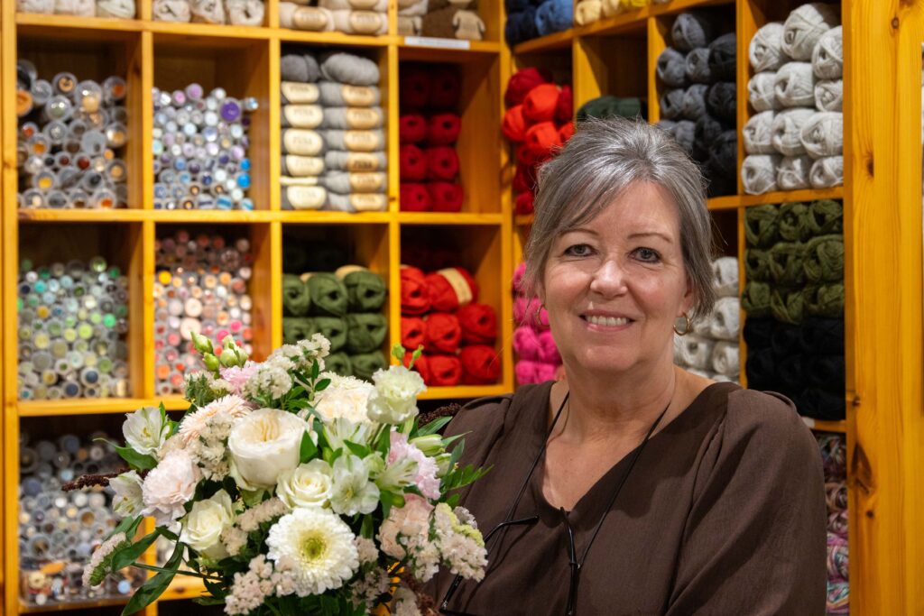 31 ÅR MED BLOMSTER: Hanne Lisbeth Pedersen har jobbet med blomster i Sandnessjøen i 31 år. Hun mener butikkene på senteret er avhengige av hverandre, og er særlig glad for at senteret har klart å holde lokalene fylt gjennom årene.