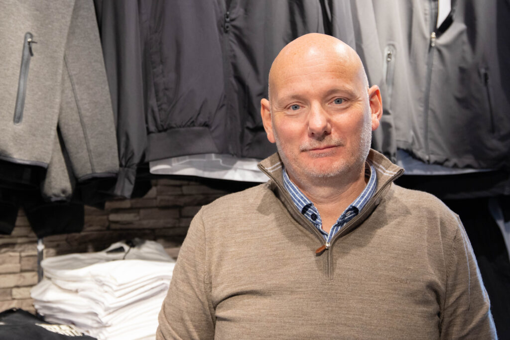 ET ANDRE HJEM: Frank Ove Schei kjøpte butikken i 1997 og har jobbet der enda lenger. Etter ti år i dagens senter beskriver han arbeidsplassen som sitt «andre hjem» – og håper han fortsatt er på plass når senteret fyller 20 år.